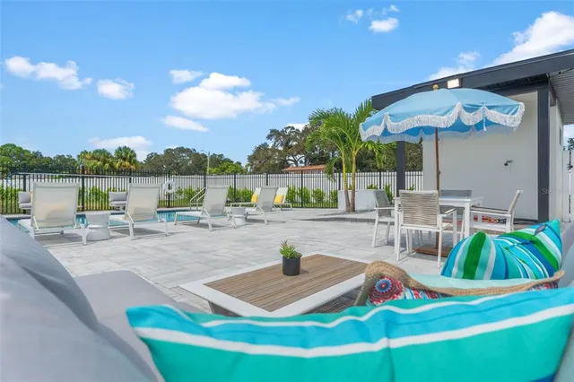 a view of a backyard with swimming pool and sitting area
