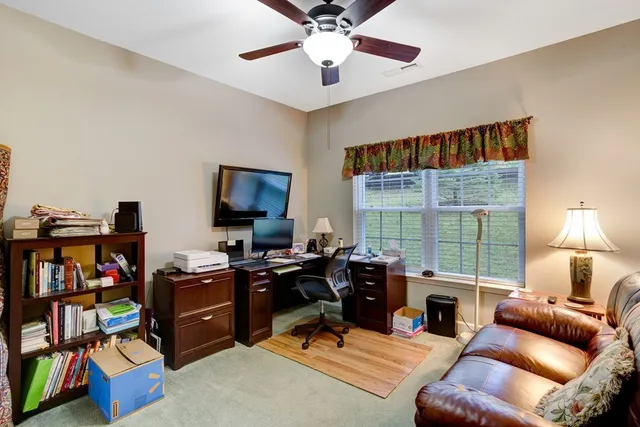 a livingroom with workspace and a window