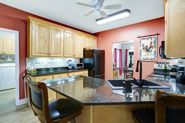 a kitchen with stainless steel appliances granite countertop a sink refrigerator and microwave