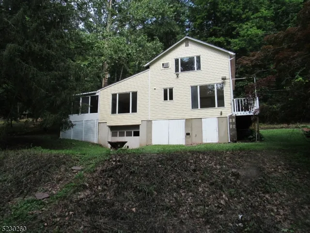 a white house sitting in middle of the forest