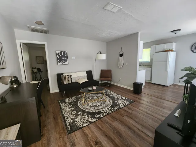 a living room with furniture and wooden floor
