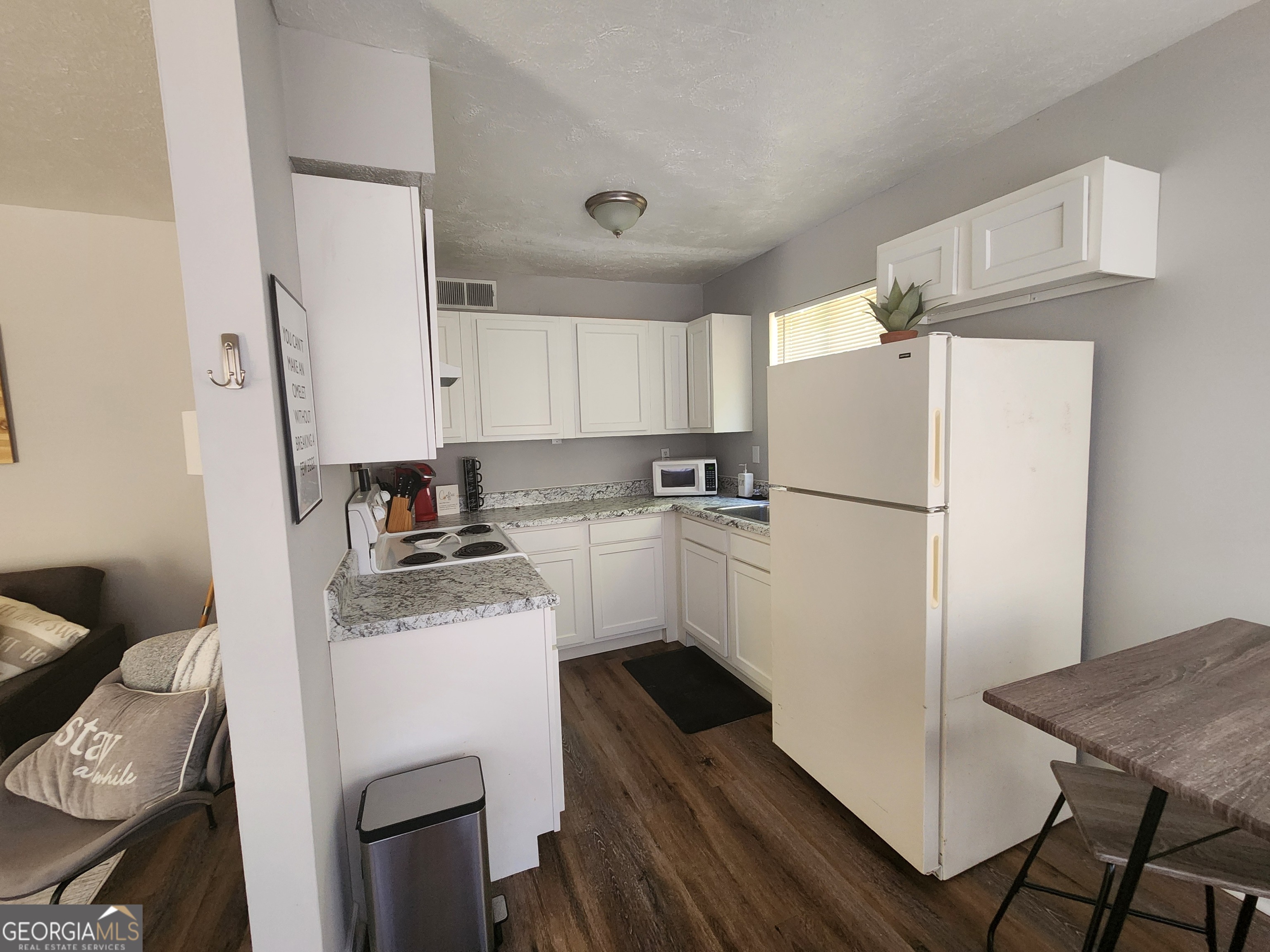 917 Oakview Avenue, Unit D Columbus, GA 31906 - Photo 6 of 13 a kitchen with a refrigerator a stove and white cabinets