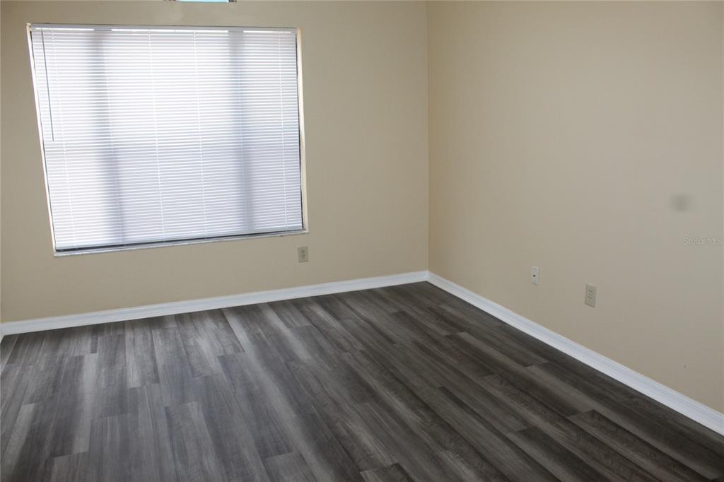 9869 Aloma Bend Lane Oviedo, FL 32765 - Photo 7 of 15 an empty room with wooden floor and windows