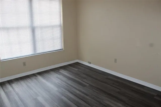 a room with wooden floor and windows