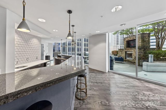 a kitchen with granite countertop a stove a sink and a wooden floors