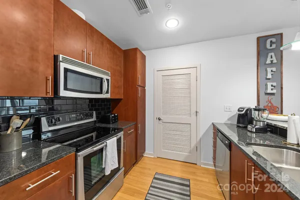 a kitchen with granite countertop a sink and steel appliances
