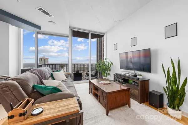 a living room with furniture a large window and a flat screen tv