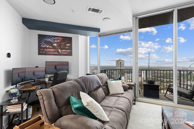 a living room with furniture a lamp and a large window