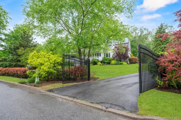 a view of a house with a big yard and large trees