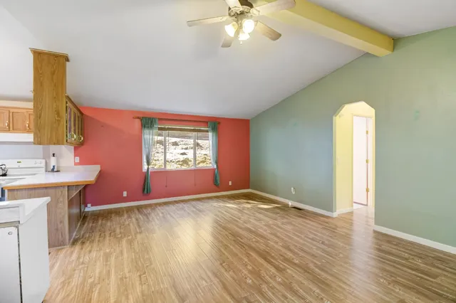 a spacious bedroom with a large bed a chandelier and windows