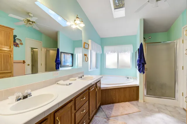 a spacious bathroom with a sink double vanity granite and a mirror