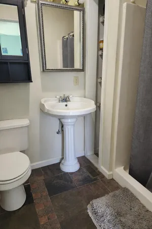 a bathroom with a sink a toilet and mirror