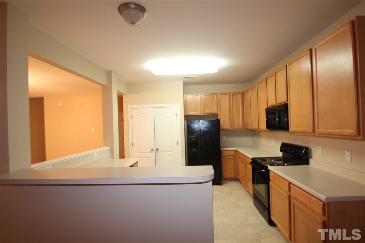 3112 Trassacks Drive Raleigh, NC 27610 - Photo 4 of 13 a kitchen with stainless steel appliances granite countertop a refrigerator a stove and a sink with wooden floor