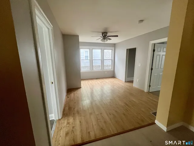 a view of hallway with window and a ceiling fan