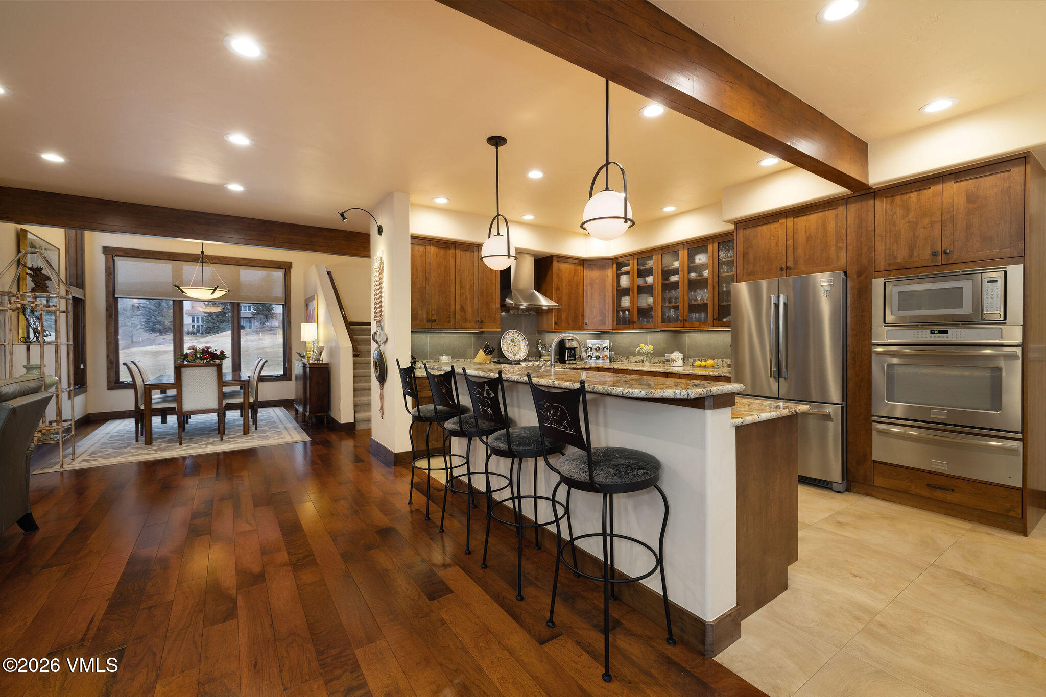 150 Buckboard Road Edwards, CO 81632 - Photo 8 of 27 a kitchen with stainless steel appliances kitchen island granite countertop a refrigerator a stove a sink and a dining table with wooden floor