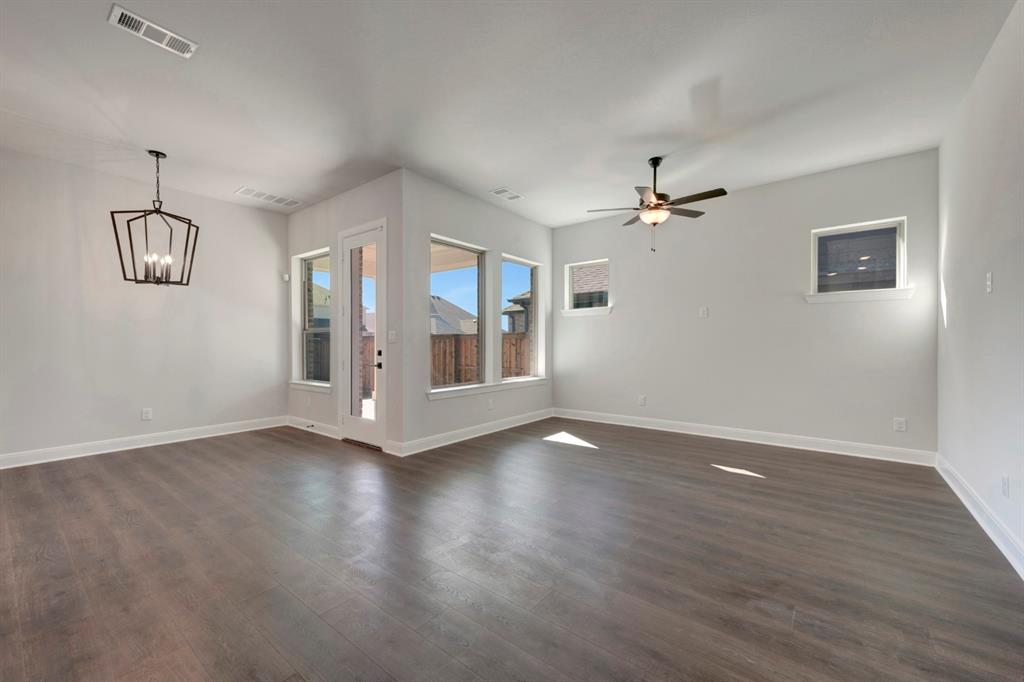 1857 Lightner Road Van Alstyne, TX 75495 - Photo 24 of 29 an empty room with wooden floor chandelier fan and windows