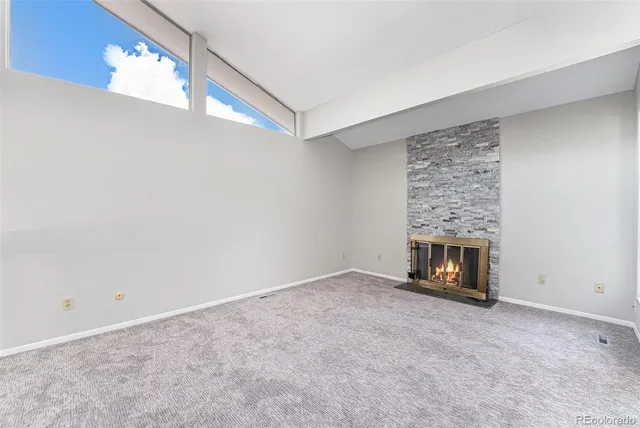 a view of an empty room with a fireplace and a window