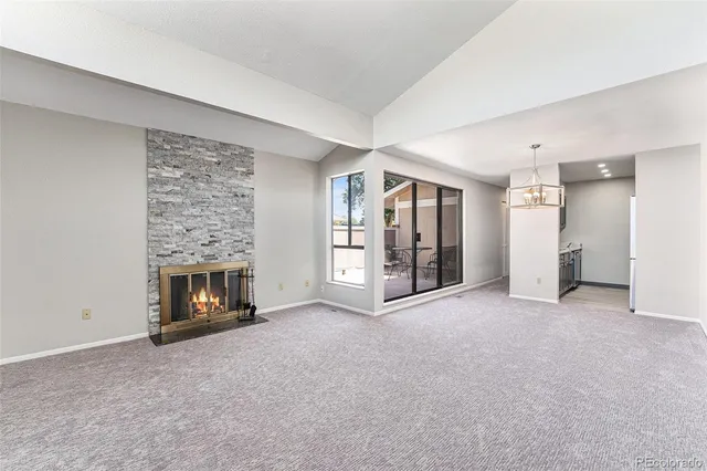 a view of an empty room with a fireplace and a window