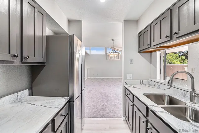 a kitchen with stainless steel appliances granite countertop a sink refrigerator and cabinets