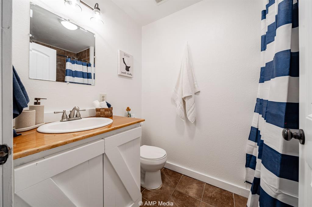 941 Harold Street Albany, TX 76430 - Photo 15 of 22 a bathroom with a sink a toilet and shower