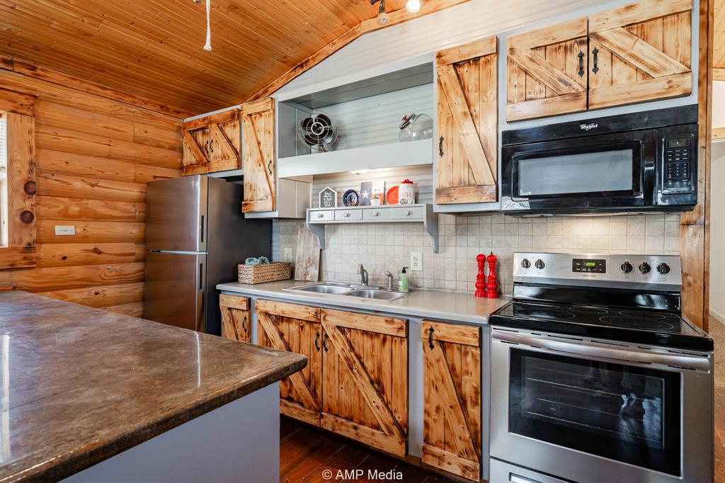 941 Harold Street Albany, TX 76430 - Photo 10 of 22 a kitchen with stainless steel appliances granite countertop a stove and a microwave