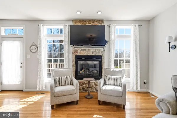 a view of a kitchen with stainless steel appliances granite countertop a stove top oven a sink a dining table and chairs