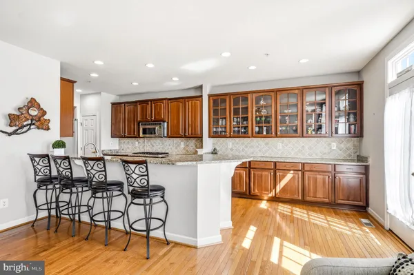 a living room with stainless steel appliances furniture and a kitchen view