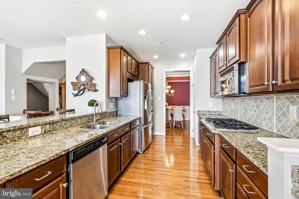 a kitchen with stainless steel appliances granite countertop a stove and a sink