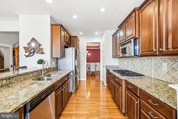 a kitchen with granite countertop a sink stove and cabinets