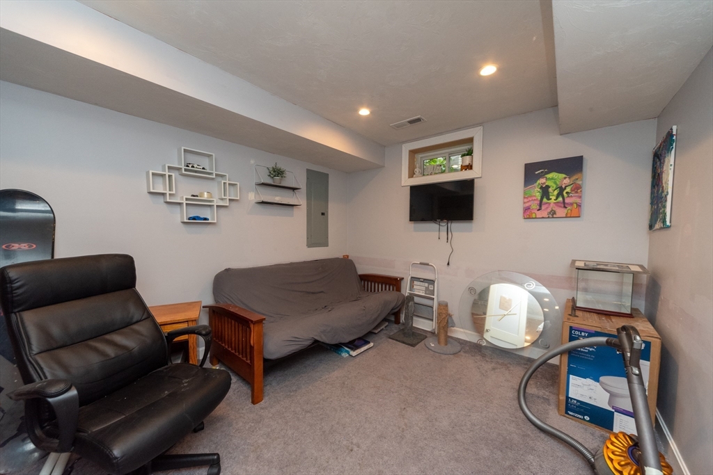 38 Norman Street Clinton, MA 01510 - Photo 30 of 40 a living room with furniture a flat screen tv and gym equipment
