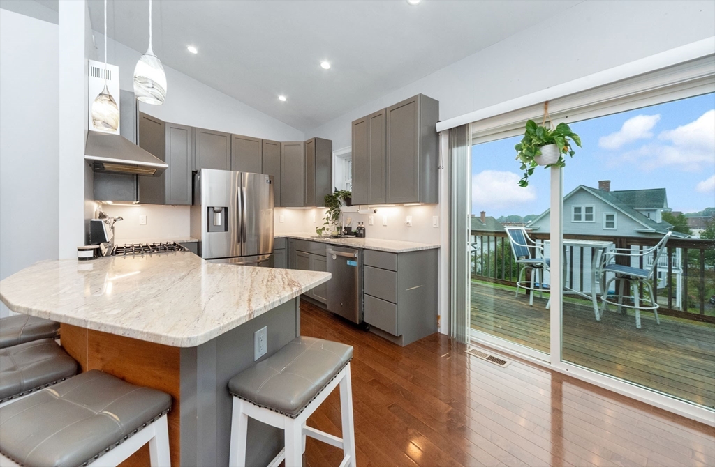 38 Norman Street Clinton, MA 01510 - Photo 9 of 40 a kitchen with stainless steel appliances kitchen island granite countertop a table chairs and a refrigerator