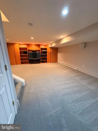 a view of an empty room with stairs and furniture