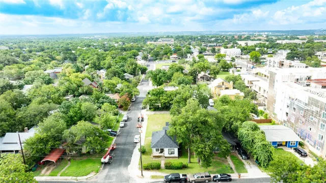 an aerial view of residential houses with outdoor space and trees