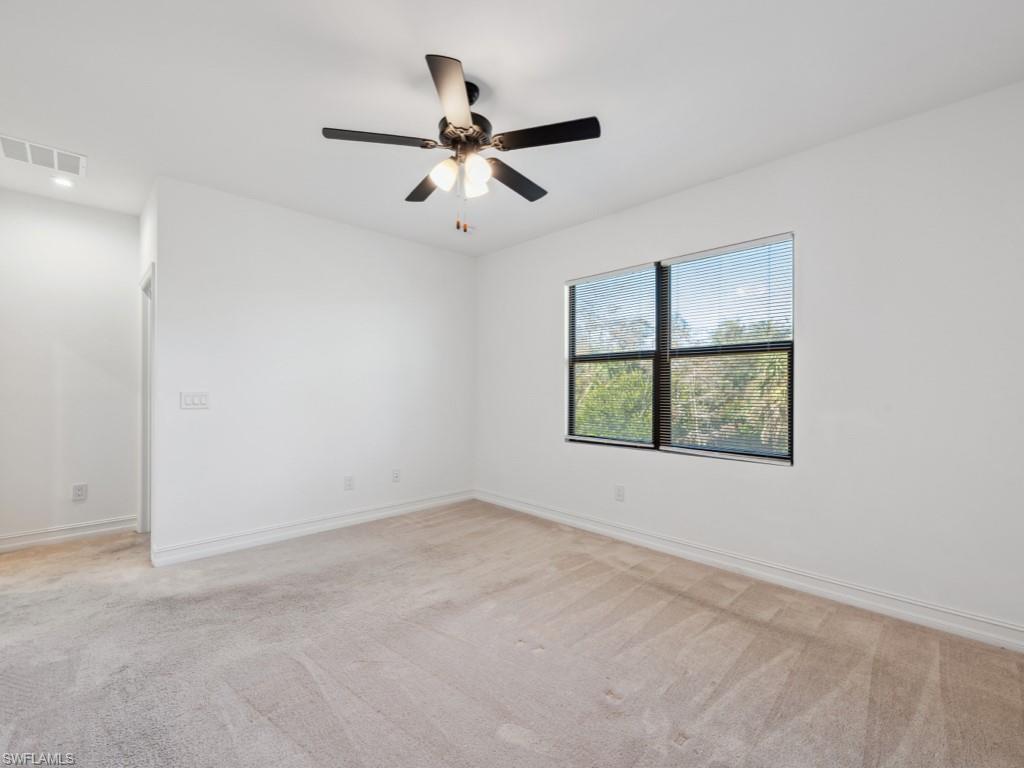 7591 Morgan Way Naples, FL 34119 - Photo 17 of 27 Spare room with light colored carpet and ceiling fan