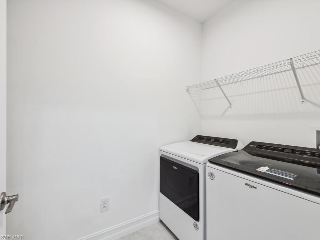 7591 Morgan Way Naples, FL 34119 - Photo 20 of 27 Laundry room featuring light tile patterned floors and washer and clothes dryer