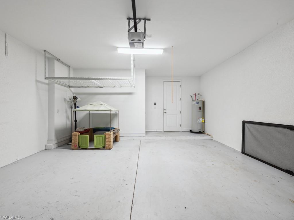 7591 Morgan Way Naples, FL 34119 - Photo 23 of 27 Garage with a garage door opener and water heater