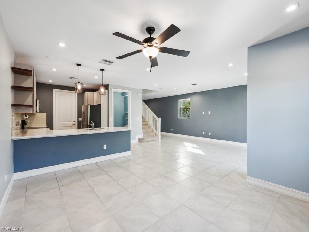 7591 Morgan Way Naples, FL 34119 - Photo 3 of 27 Unfurnished living room featuring ceiling fan and sink