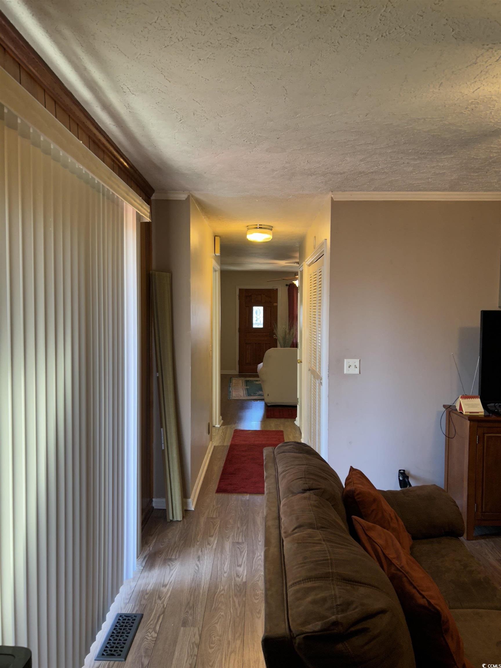 1411 East Harrison Street Dillon, SC 29536 - Photo 20 of 40 Living area featuring a textured ceiling, wood finished floors, and crown molding