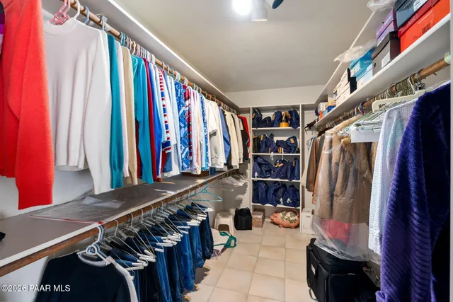 a view of walk in closet with clothes and shoes