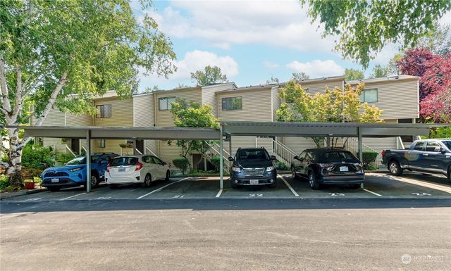 an outdoor space with lots of cars parked on the road