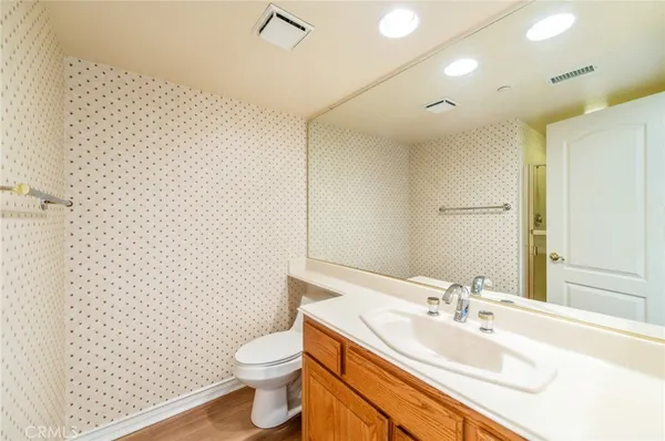 a bathroom with a granite countertop toilet sink and mirror