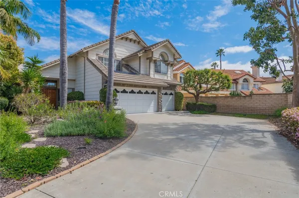 a front view of a house with a yard and potted plants