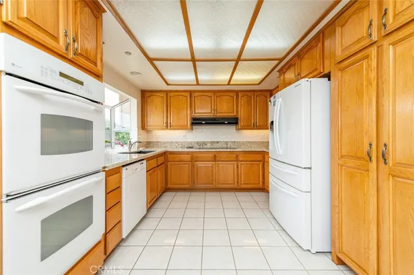 a kitchen with stainless steel appliances granite countertop a refrigerator and a stove top oven