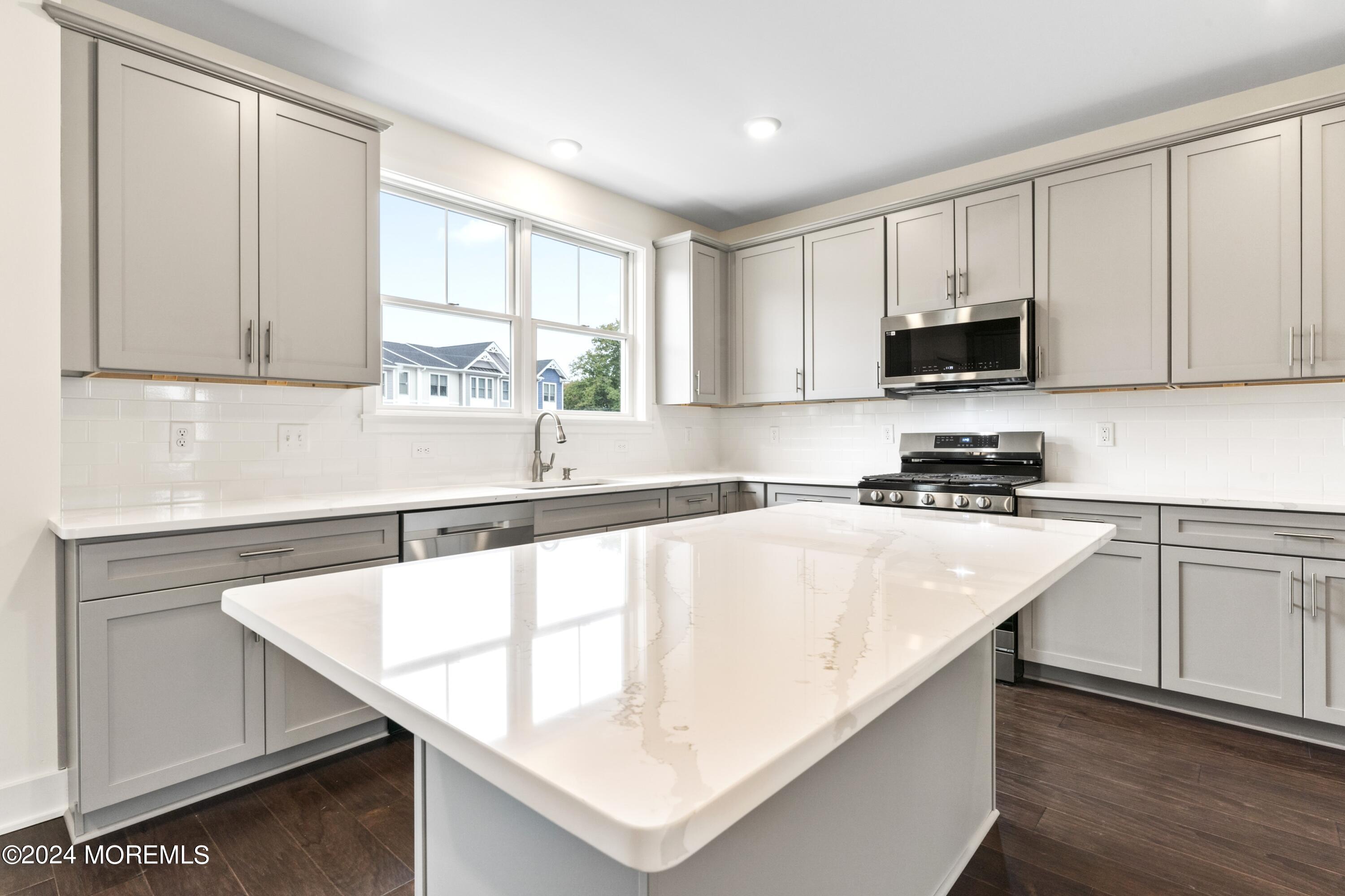 25 Raritan Cove Keyport, NJ 07735 - Photo 16 of 50 a kitchen with stainless steel appliances granite countertop a sink a stove and white cabinets