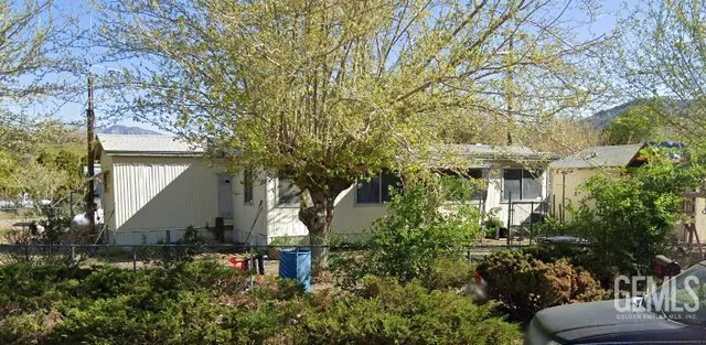 a front view of a house with a yard and tree s