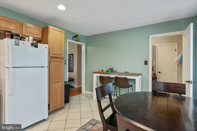 a kitchen with a refrigerator a table and chairs