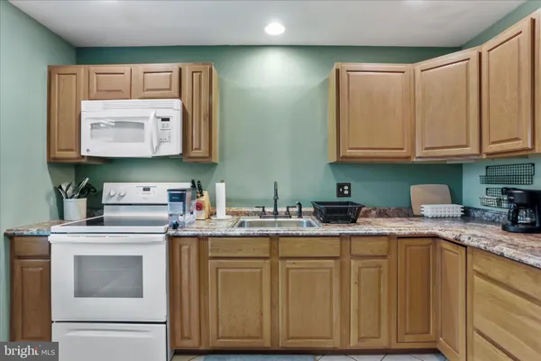 a kitchen with granite countertop cabinets stainless steel appliances and a sink