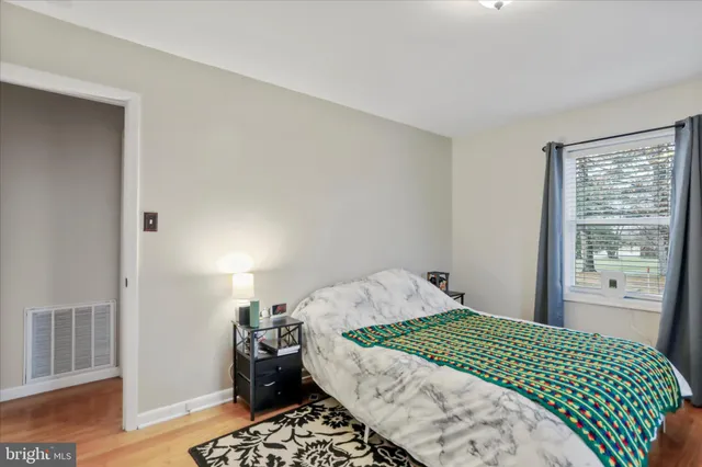 a bedroom with a bed and wooden floor