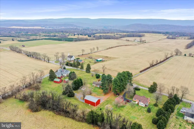 an aerial view of residential house with outdoor space and trees all around