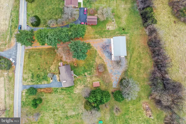 an aerial view of ocean and residential houses with outdoor space